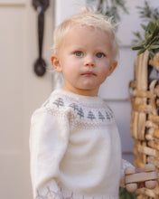 Load image into Gallery viewer, Close-up of a toddler wearing a cream knit sweater with gray trees and pale geometric detailing around the neckline.
