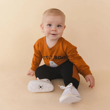 Load image into Gallery viewer, A baby sitting on a beige studio floor wearing an orange long-sleeve shirt with 'LITTLE BOO' and a ghost graphic, black pants, and white sneakers.
