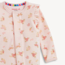 Load image into Gallery viewer, A close-up of a baby long-sleeve sleep sack by Magnetic Me, featuring a light pink base with a delicate floral print in shades of pink, yellow, and green, and ruffled detailing on the shoulders.
