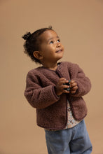 Load image into Gallery viewer, Child wearing the brown teddy jacket over a floral top with blue jeans.
