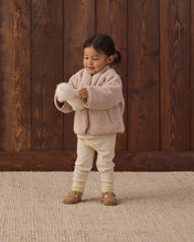 Load image into Gallery viewer, Toddler standing in a rose water pink shearling zip jacket and cream pants, holding a white plush toy.
