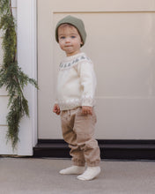 Load image into Gallery viewer, Side view of a toddler in latte tan pants, showing a large patch pocket and elastic ankle cuffs.

