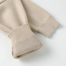 Load image into Gallery viewer, Close-up of a beige knit garment sleeve with ribbed cuff, showing the textured knit fabric on a clean white background.
