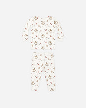 Load image into Gallery viewer, Cream two-piece pajama set with long sleeves and matching pants, printed with rocking horses, teddy bears, and holiday toys.
