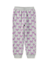 Load image into Gallery viewer, Light gray jogger pants with an all-over purple bow pattern, featuring an elastic waistband and ribbed ankle cuffs, shown flat on a white background.
