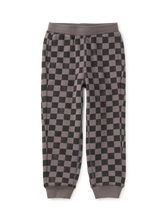 Load image into Gallery viewer, A pair of children's jogger pants featuring a dark gray and brown checkerboard pattern, with solid brown ribbed waistband and cuffed ankles, shown flat on a white background.
