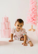 Load image into Gallery viewer, Baby sitting with one leg extended in the Sugar Plum romper, showing its relaxed legs and ruffled ankle cuffs.
