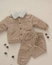 Load image into Gallery viewer, Latte tan drawstring pants laid beside a matching jacket with a cream fleece collar and scattered pine cones.
