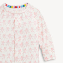 Load image into Gallery viewer, A close-up of a baby long-sleeve sleep sack or pajama top in white with a repeating light pink fairy print. The garment features a round neckline with a colorful striped inner trim and a snap-button front closure.
