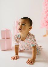 Load image into Gallery viewer, Baby looking upward while on hands and knees in a Sugar Plum romper beside pink wrapped gifts.
