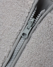 Load image into Gallery viewer, Close-up of the fog gray jacket’s zipper, matching trim, and curly shearling texture.
