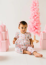 Load image into Gallery viewer, Baby seated in a pale pink Sugar Plum romper with puff sleeves and ruffled ankle cuffs beside pink gifts and a Christmas tree.
