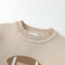 Load image into Gallery viewer, Close-up of a beige knit crewneck sweater showing the ribbed collar and a brown and white football graphic at the bottom.
