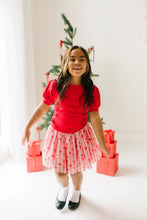 Load image into Gallery viewer, Child jumping in a pink Dainty Bows tulle skirt and red top, with the gathered skirt flaring outward.
