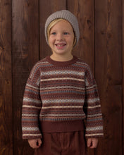 Load image into Gallery viewer, Child wearing a patterned sweater and knit hat against a wooden background
