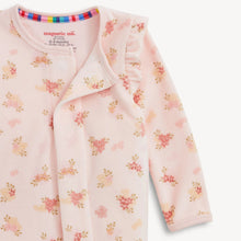 Load image into Gallery viewer, A close-up of a baby long-sleeve sleep sack by Magnetic Milk, featuring a light pink base with a delicate floral print in shades of peach, yellow, and green. The garment has a ruffled collar and a magnetic snap closure.
