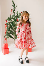 Load image into Gallery viewer, Child standing with hands in the side pockets of a pink Dainty Bows dress, paired with black Mary Jane shoes.
