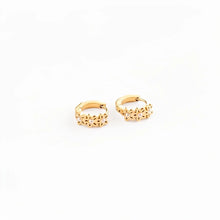 Load image into Gallery viewer, Pair of gold-tone daisy hoop earrings with flower-shaped details and pale centers, showing the hinged closures on a white background.
