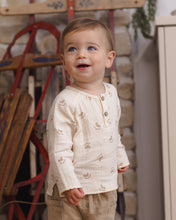 Load image into Gallery viewer, Close-up of a toddler wearing the cream rocking-horse print shirt, showing the button neckline and side-slit hem.
