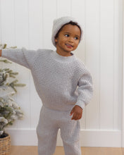 Load image into Gallery viewer, Quincy Mae fog-gray chunky knit pants with a drawstring waist and ribbed ankle cuffs, shown on a boy wearing a matching sweater and hat, standing and smiling.
