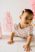 Load image into Gallery viewer, Baby crawling toward the camera in a pale pink Sugar Plum romper with short puff sleeves.
