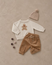 Load image into Gallery viewer, Relaxed Raglan Sweater in Gingerbread Man, cream, laid flat with pants and a hat
