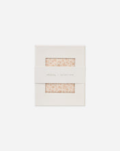 Load image into Gallery viewer, A square cream-colored paper packaging box with two small rectangular cutouts showing a light beige and pink floral patterned fabric inside. A white paper band wrapped around the middle has the text 'sillybaby x QUINCY MAE' printed in a delicate serif font.
