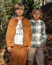 Load image into Gallery viewer, Two boys standing outdoors in a wooded setting, wearing coordinated western-style clothing. The boy on the left wears a tan suede jacket and matching corduroy pants over a white graphic T-shirt.
