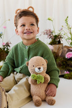 Load image into Gallery viewer, Child seated beside Ollie the Otter plush, showing its cream muzzle, brown paws, and little green turtle.
