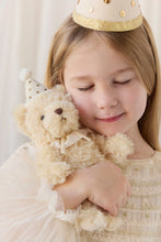 Load image into Gallery viewer, Child wearing a cream and gold party hat, holding Party Arthur teddy bear beside their face.
