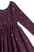 Load image into Gallery viewer, Close-up of a long-sleeve dress in deep purple with a small scattered floral print, showing the bodice seam and gathered skirt on a white background.
