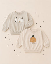 Load image into Gallery viewer, Two children's long-sleeve sweatshirts in a warm cream color, displayed flat on a matching cream background with small black star decorations. The top sweatshirt features three white ghosts with black hats and the text 'Trick or Treat!'.

