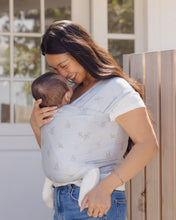 Load image into Gallery viewer, Woman carrying a baby in a sling outdoors
