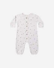 Load image into Gallery viewer, A white long-sleeve baby romper with small black star patterns and a button-up front, displayed flat against a light gray background.
