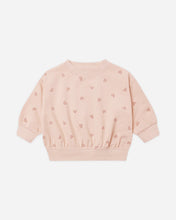 Load image into Gallery viewer, A light pink long-sleeve sweatshirt with a small repeating heart pattern, featuring a crew neck and elastic cuffs and hem, shown flat on a light gray background.
