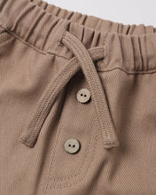Load image into Gallery viewer, Close-up of a pair of taupe-brown knit pants featuring an elasticized waistband, a matching braided drawstring, and two decorative buttons.
