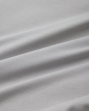 Load image into Gallery viewer, A close-up of light gray fabric with soft diagonal folds and a smooth woven texture.
