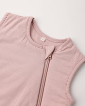 Load image into Gallery viewer, Close-up of a sleeveless dusty pink top with a front zipper and a small white brand tag inside the collar, shot on a light neutral background.
