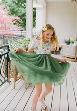 Load image into Gallery viewer, Young girl in a floral top and green skirt on a porch
