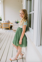 Load image into Gallery viewer, Young girl in a green dress standing on a porch
