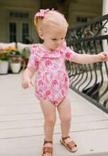 Load image into Gallery viewer, Child wearing a pink horseshoe print romper on a wooden deck.
