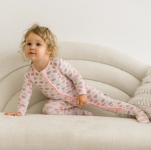 Load image into Gallery viewer, Child wearing a pink outfit with a pattern on a beige couch
