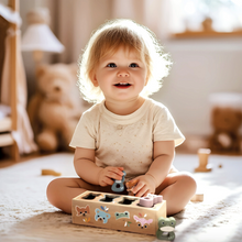 Load image into Gallery viewer, Child playing with a wooden shape sorting toy in a cozy room.
