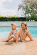 Load image into Gallery viewer, Two young girls sitting by a pool with a scenic background
