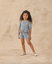 Load image into Gallery viewer, Young girl wearing a checkered outfit on a beige background

