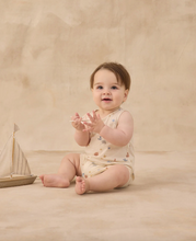 Load image into Gallery viewer, Baby sitting on a beige surface with a small wooden sailboat toy.
