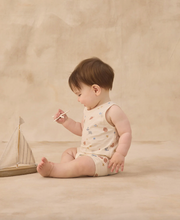 Load image into Gallery viewer, Baby sitting on a beige surface holding a toy boat against a beige background
