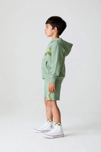 Load image into Gallery viewer, Child wearing a green hoodie and shorts set on a white background
