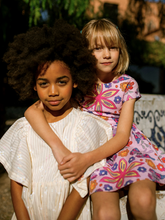 Load image into Gallery viewer, Two children sitting together outdoors with a blurred background
