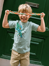 Load image into Gallery viewer, Child holding colorful hula hoop in front of a green door
